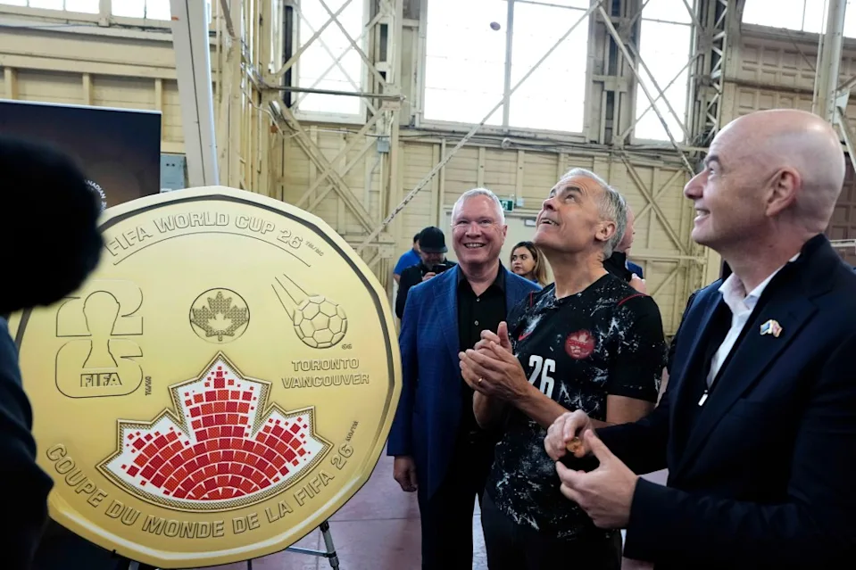 Prime Minister Mark Carney flips a Royal Canadian Mint FIFA World Cup coin at an event in Ottawa on May 24, 2026.